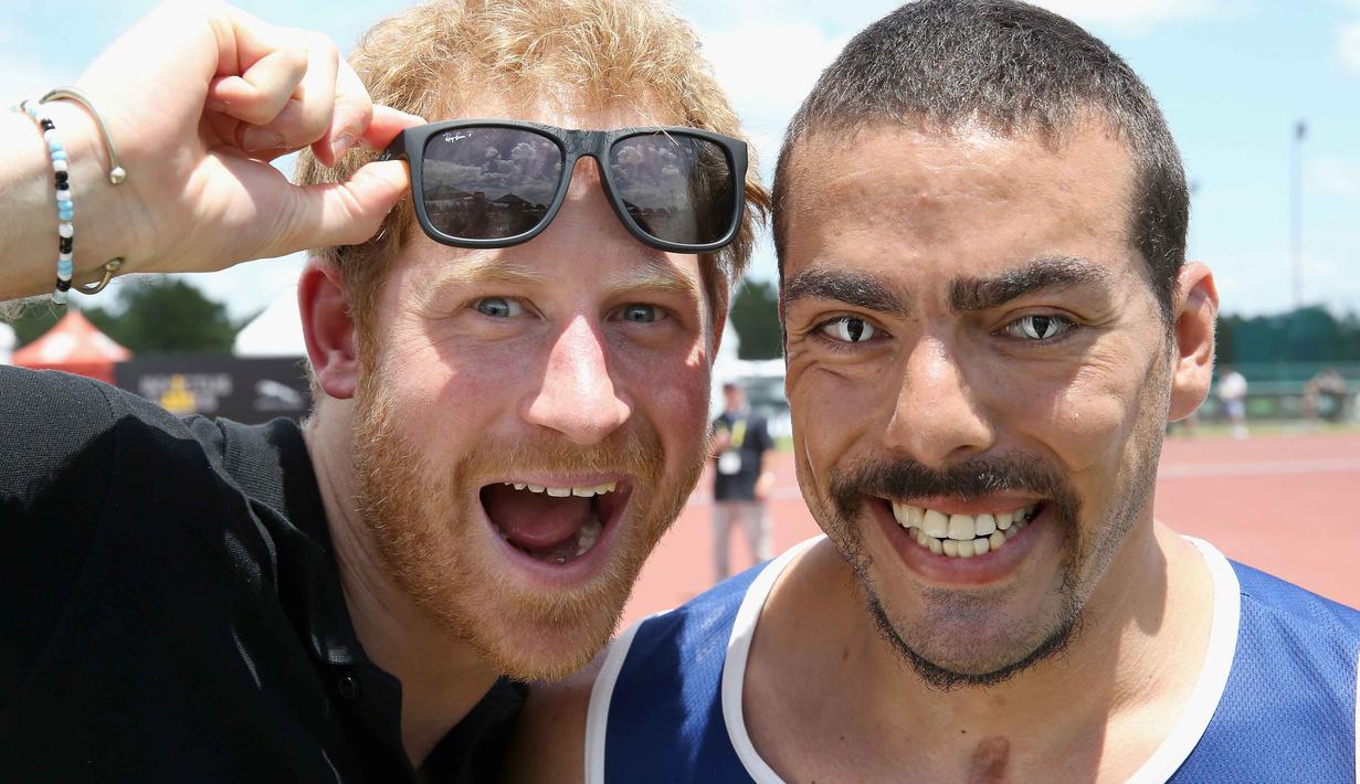 Pangeran Harry berfoto dengan atlet AS, Michael Kacer sebelum bertanding pada ajang ajang Invictus Games Orlando 2016 di ESPN Wide World of Sports complex, (10/5/2016), Lake Buena Vista, Florida.   (Chris Jackson/Getty Images for Invictus/AFP)