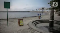 Petugas membersihkan pantai ancol yang sepi usai ditutup antisipasi COVID-19, Jakarta, Sabtu (14/3/2020). Selama masa penutupan, Taman Impian Jaya Ancol akan melakukan kegiatan overhaul seluruh wahana dan membersihkan fasilitas rekreasi dengan disinfektan. (Liputan6.com/Faizal Fanani)