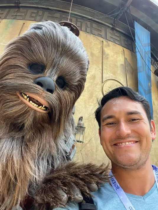 Yang bikin Arifin Putra bungah saat ke Disneyland, melihat wahana Star Wars at World’s Edge. Ia pamer foto pose tersenyum lebar bareng karakter Chewie seraya menyebut dirinya Han Solo. “Chewie and Han Solo reunited at last!” cetusnya di medsos, 9 September 2022. “Saya ngefans banget dengan Star Wars dari dulu. Waktu saya bisa main wahana Rise of the Resistance saya terpukau banget karena ada campuran role playing dan permainan wahana realistis. Keren banget!” cetus Arifin Putra. (Foto: Dok. Koleksi Pribadi Arifin Putra)