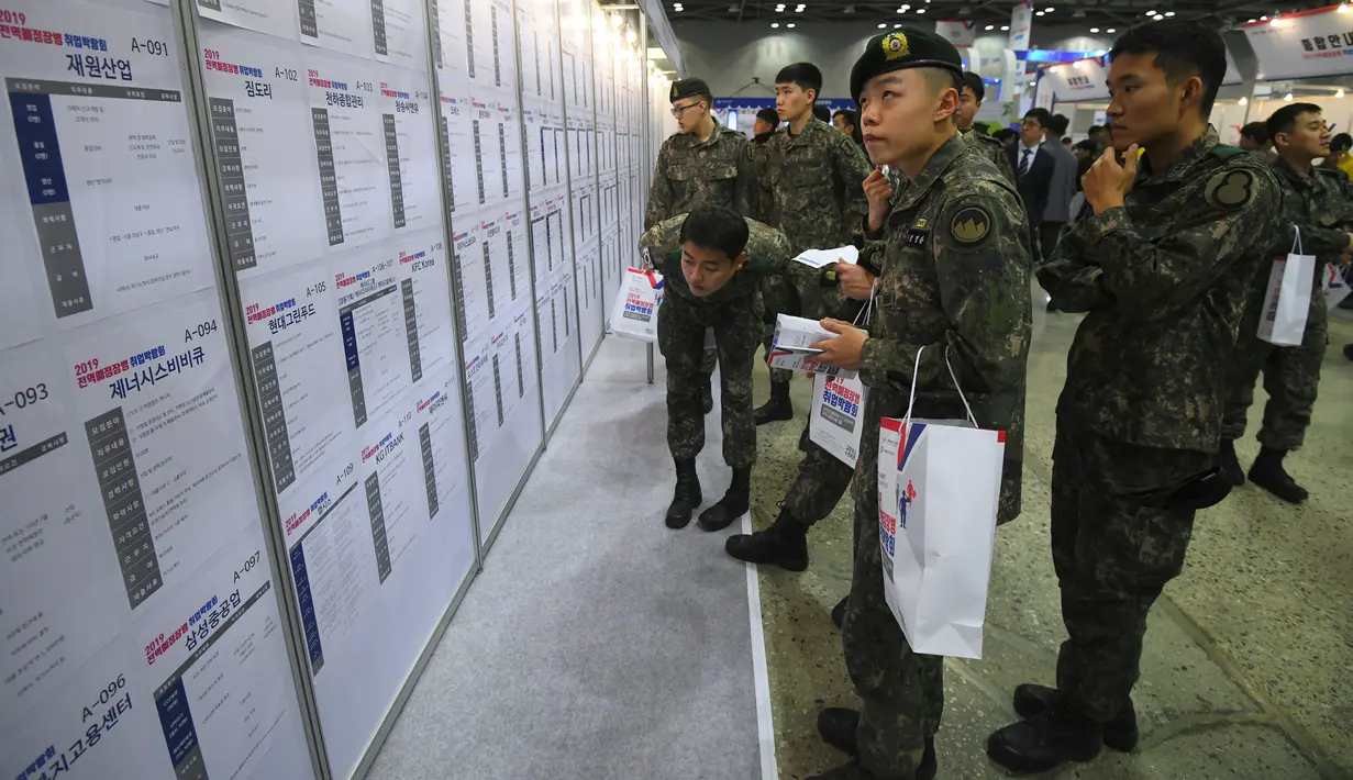 Tentara Korea Selatan membaca informasi pekerjaan saat mengikuti job fair di ruang pameran KINTEX, Goyang, Korea Selatan, Rabu (20/3). Job fair bagi para tentara ini dgelar setiap tahun. (JUNG Yeon-Je/AFP)
