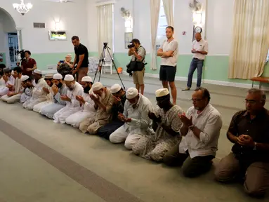 Komunitas muslim AS memanjatkan doa untuk para korban penembakan massal komunitas gay di Islamic Center of Fort Pierce, Fort Pierce, Florida, Minggu (12/6). (Reuters/Joe Skipper)