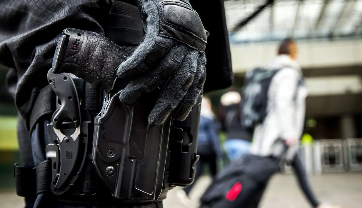 Seorang polisi berjaga di pintu masuk sebuah stasiun di Rotterdam, Senin (18/3). Pihak keamanan di Belanda meningkatkan keamanan di bandara dan bangunan penting lainnya usai penembakan di Utrecht yang menewaskan 3 orang.  (KOEN VAN WEEL/ANP/AFP)