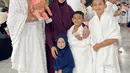 Kartika Putri saat Umrah tampil mengenakan one set warna maroon, dari kerudung panjang dan abaya. [@kartikaputriwolrd]