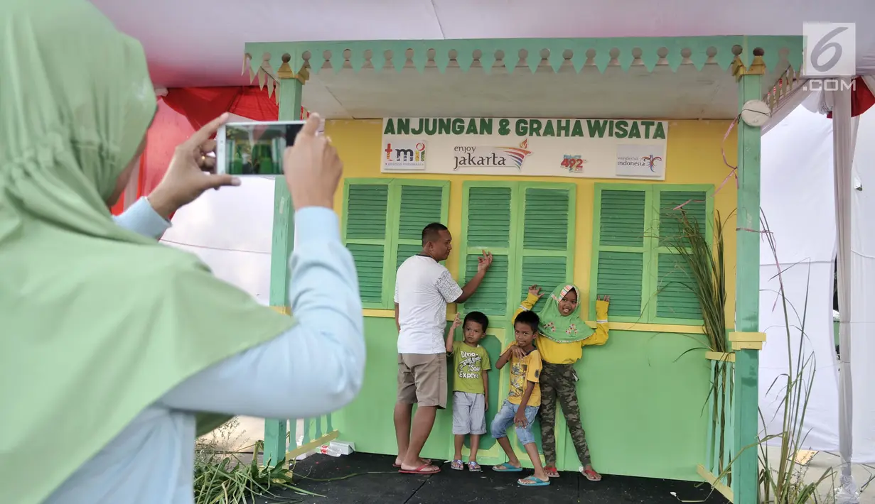 Warga saat mengunjungi salah satu rumah adat Betawi selama Lebaran Betawi 2019 di Monas, Jakarta, Minggu (21/7/2019).Untuk pertama kalinya Lebaran Betawi digelar di Monas yang diisi oleh beragam seni dan budaya masyarakat Betawi dalam rangka memeriahkan HUT DKI Jakarta.(merdeka.com/Iqbal S. Nugroho)
