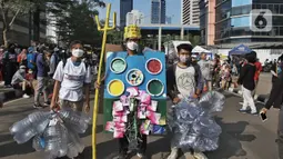 Sejumlah aktivis dari berbagai organisasi melakukan Aksi pawai bebas plastik saat Hari Bebas Kendaraan (Car Free Day) di Jakarta, Minggu (24/7/2022). Aksi tersebut mengajak masyarakat untuk peduli lingkungan dari sampah plastik kemasan atau sekali pakai yang saat ini banyak mencemari laut di Indonesia. (Liputan6.com/Angga Yuniar)