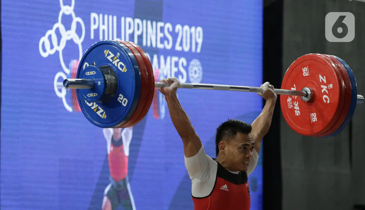 Lifter Eko Yuli melakukan angkatan saat SEA Games 2019 cabang angkat besi nomor 61 kg di Stadion Rizal Memorial, Manila, Filipina, Minggu (1/12/2019). Dirinya meraih emas dengan total angkatan 309 kg. (Bola.com/M Iqbal Ichsan)