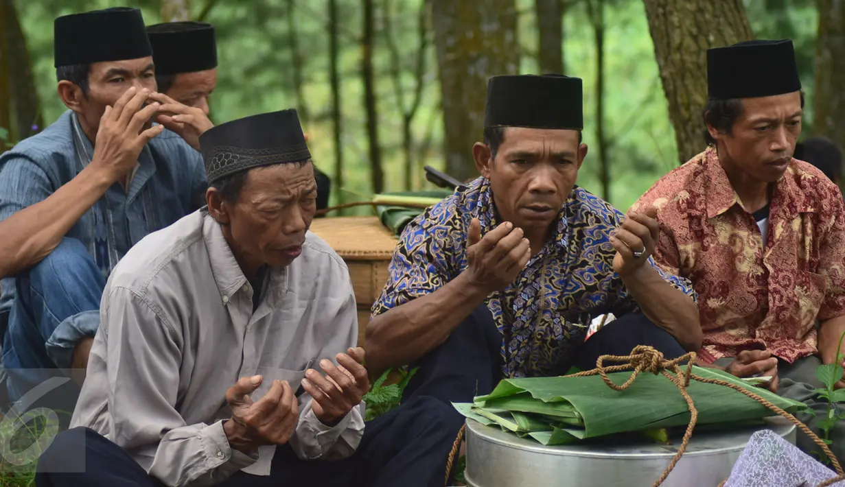 Sejumlah warga berdoa sebelum makan saat prosesi Sadranan Asyura di makam kiai kramat di bukit Tlogo Pucang, Kandangan, Temanggung, Rabu  (12/10).  (Liputan6.com/Gholib)