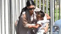 Kim Kardashian tetap gendong Nori meski kandugannya mulai membesar (dailymail.com)