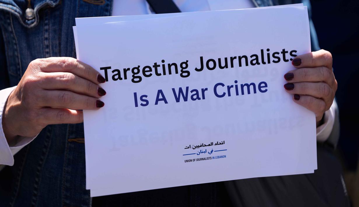 Diketahui, ketika serangan tersebut terjadi, Amal Khalil sedang berada di sebuah rumah di desa Al-Tiri untuk berlindung. Tampak dalam foto, seorang jurnalis memegang plakat selama aksi duduk menentang pembunuhan jurnalis Lebanon Amal Khalil yang tewas dalam serangan udara Israel pada Rabu 22 April 2026 dan jurnalis lainnya, di Beirut, Lebanon, Kamis, 23 April 2026. (AP Photo/Hussein Malla)