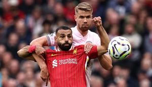 Pemain Liverpool, Mohamed Salah berebut bola dengan pemain Brentford, Kristoffer Ajer pada laga lanjutan Liga Inggris 2024/2025 di Anfield, Liverpool, Inggris, Minggu (25/08/2024) malam WIB. (AFP/Darren Stapless)