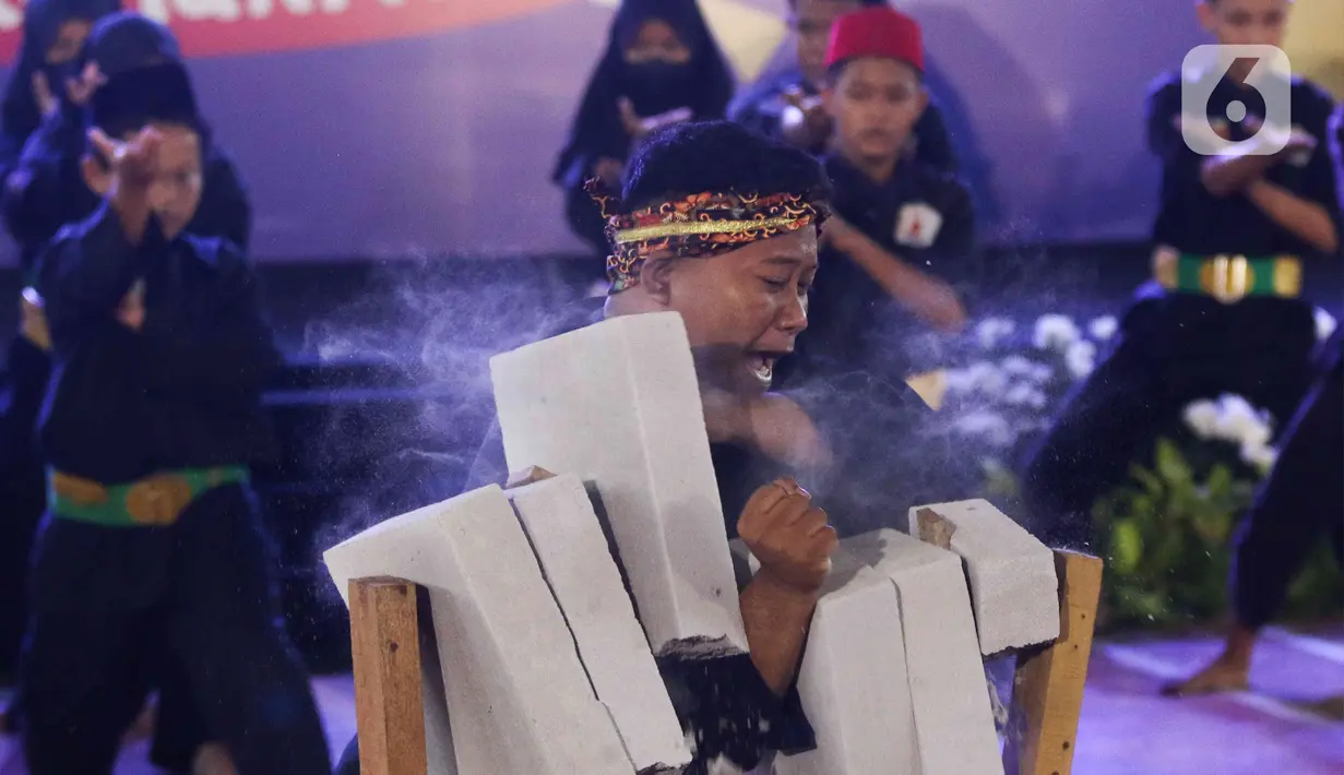 Aksi pesilat saat melakukan pentas di Gor Ciracas, Jakarta, Selasa (22/3/2022). Dinas Kebudayaan DKI bersama sejumlah Komunitas Budaya menggelar pergelaran seni budaya yang bertujuan untuk memperkenalkan kebudayaan pencak silat serta mengangkat kembali tradisi budaya. (Liputan6.com/Herman Zakharia)