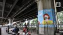 Pengendara motor melintasi mural bertema protokol kesehatan Covid-19 yang menghiasi tiang pancang jalan tol di Jalan Ahmad Yani, Jakarta, Minggu (13/12/2020). Warna-warni mural ini dibuat oleh seniman dari berbagai daerah. (merdeka.com/Iqbal S. Nugroho)