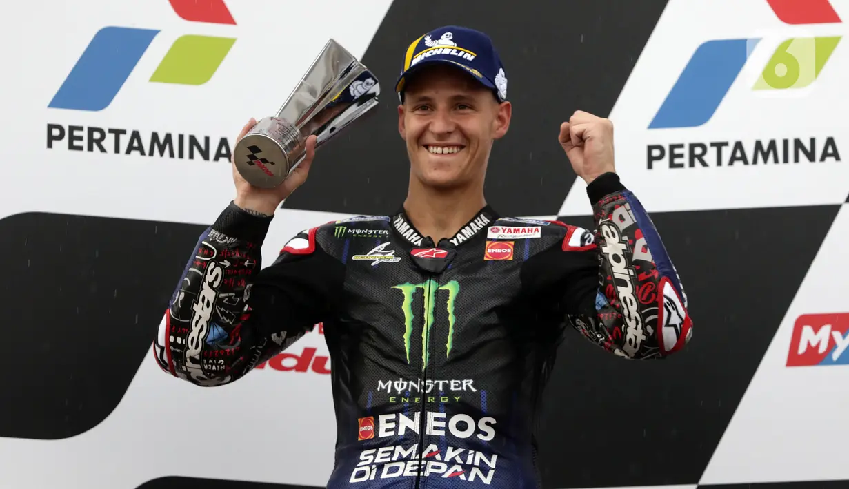 Pembalap Monster Energy Yamaha MotoGP, Fabio Quartararo mengangkat piala posisi kedua Pertamina Mandalika International Street Sirkuit, NTB, Minggu (20/3/2022). Pembalap Red Bull KTM Factory Racing, Miguel Oliveira menempati posisi pertama MotoGP Mandalika 2022. (Liputan6.com/Helmi Fithriansyah)