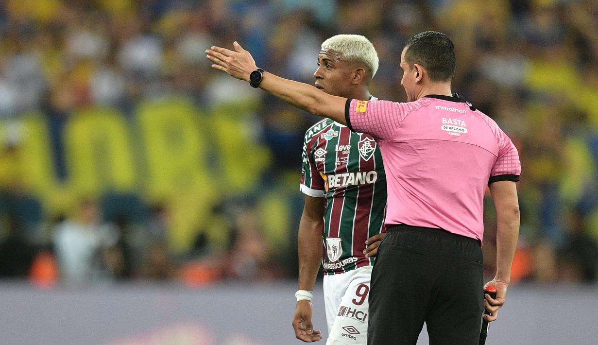 Pemain Fluminense, John Kennedy (kiri) berjalan meninggalkan lapangan setelah mendapatkan kartu merah dari wasit pada final Copa Libertadores melawan Boca Juniors yang berlangsung di Maracana Stadium , Rio de Janeiro, Brasil, 5 November 2023 WIB. (AFP/Carl De Souza)