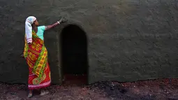 Buruh wanita mengoleskan campuran tanah liat dan kotoran sapi di atas tungku saat ia bekerja di sebuah tungku batu bata di Gauhati, India (22/11). Sebagian besar buruh di sini mendapatkan Rupee 120 (kurang dari 2 Dolar) per hari. (AP Photo/Anupam Nath)