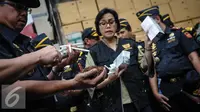 Menteri Keuangan Sri Mulyani melihat rokok ilegal di Kantor Dirjen Bea Cukai, Jakarta, Jumat (30/9). Sri Mulyani mengaku takjub dengan temuan rokok ilegal yang sudah terkemas rapi. (Liputan6.com/Faizal Fanani)