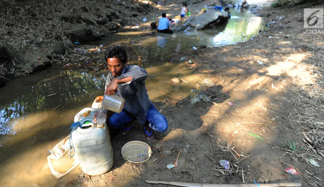 Warga mengambil air dari lubang pada aliran Sungai Cihoe untuk memenuhi kebutuhan sehari-hari termasuk air minum di kawasan Ridogalih, Cibarusah, Bekasi, Minggu (7/7/2019). Sudah lebih dari dua bulan, warga memanfaatkan sisa aliran sungai yang kotor akibat musim kemarau. (merdeka.com/Arie Basuki)