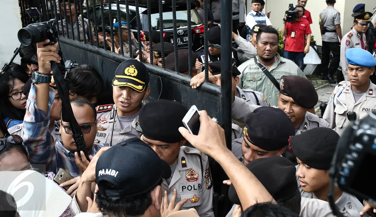 Petugas kepolisian berjaga di pintu masuk Pengadilan Negeri (PN) Jakarta Utara, Selasa (13/12). Ratusan orang membludak berebut masuk ke ruang sidang perdana Basuki Tjahaja Purnama (Ahok) yang berkapasitas maksimal 80 orang. (Liputan6.com/Faizal Fanani)