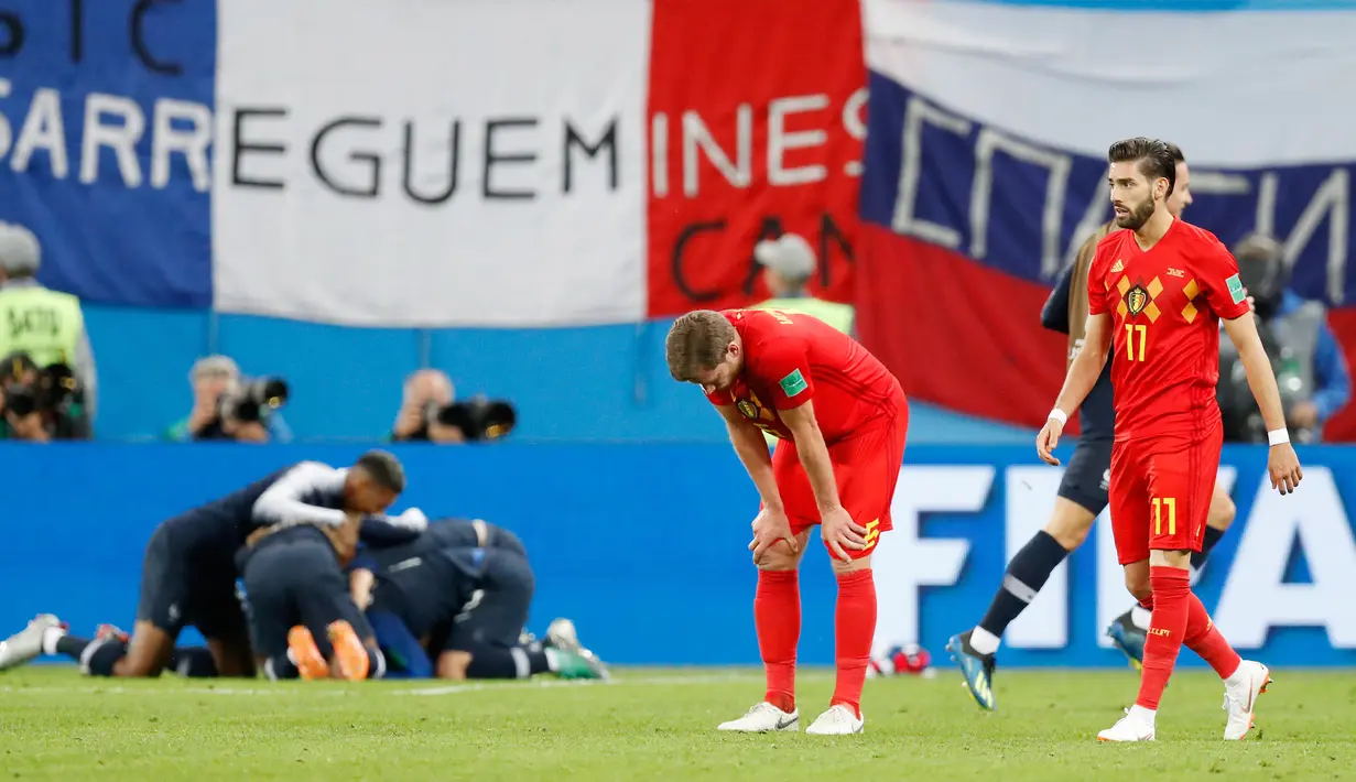 Pemain timnas Belgia, Jan Vertonghen dan Yannick Carrasco berdiri di lapangan menahan kekecewaan setelah kalah dari Prancis pada babak semifinal Piala Dunia 2018 di Stadion St. Petersburg, Selasa (10/7). Belgia tumbang 0-1 dari Prancis. (AP/David Vincent)
