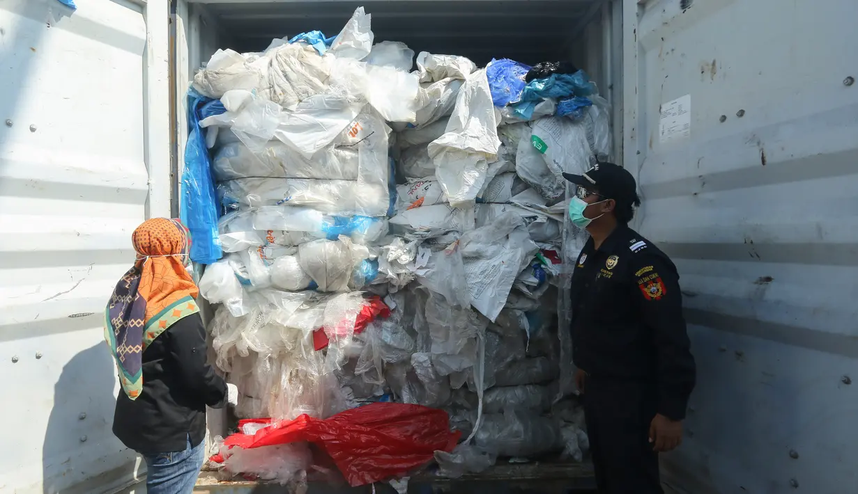 Petugas mengecek peti kemas berisi sampah plastik yang mengandung limbah berbahaya dan beracun (B3) untuk di re-ekspor di Batam, Senin (29/7/2019). Indonesia mengirim kembali (re-ekspor) tujuh peti kemas berisi limbah plastik impor ke negara asalnya, Prancis dan Hongkong. (SEI RATIFA/AFP)