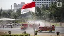 Petugas Pemadam Kebakaran menyemprotkan cairan disinfektan di lingkungan Monas, Jakarta, Rabu (17/6/2020). Penyemprotan dilakukan untuk mencegah penyebaran COVID-19 dalam rangka persiapan pembukaan kembali Monumen Nasional (Monas) pada Sabtu, 20 Juni 2020.  (Liputan6.com/Faizal Fanani)