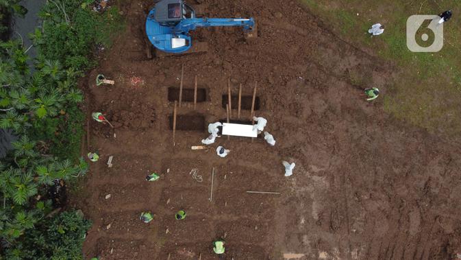 Foto udara pemakaman jenazah dengan protokol COVID-19 di TPU Srengseng Sawah, Jakarta, Kamis (21/1/2021). Sebagian lahan TPU Srengseng Sawah yang dijadikan pemakaman jenazah Covid-19 sejak Selasa (12/1) lalu, dengan kapasitas 564 petak makam kini nyaris penuh. (Liputan6.com/Helmi Fithriansyah)