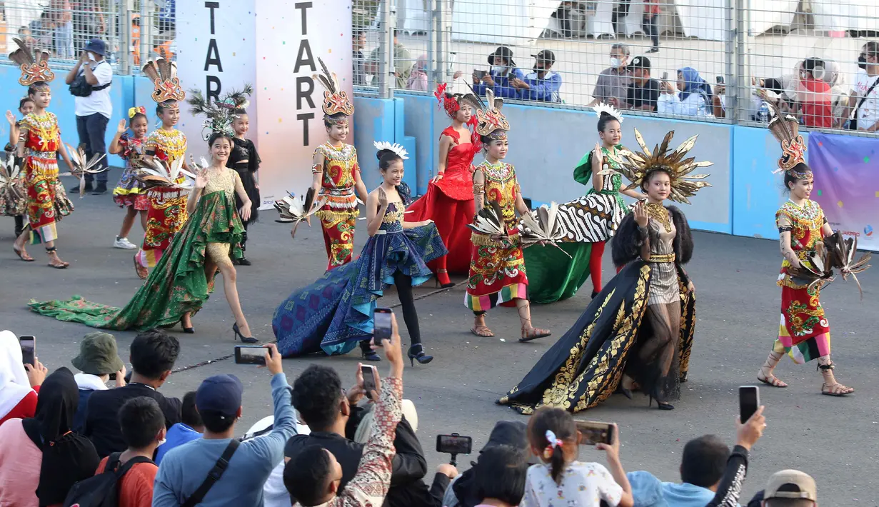 Peserta berparade dalam pagelaran Jakarnaval 2022 di Jakarta International Eprix Circuit, Ancol, Minggu (14/8/2022). Gelaran Jakarnaval 2022 yang mengangkat tema "Kekayaan Intelektual Nusantara untuk Dunia" tersebut menampilkan parade komunitas pegiat seni budaya, marching band, dan kendaraan hias. (Liputan6.com/Herman Zakharia)