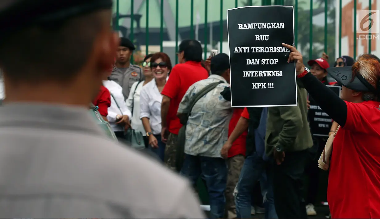 Seorang wanita membawa poster saat aksi di depan Gedung DPR , Jakarta, Rabu (12/7). Dalam aksinya mereka menuntut Rampungkan RUU Anti - Terorisme, Tolak Hak Angket KPK, dan Bubarkan DPR. (Liputan6.com/Johan Tallo)