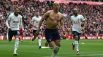 Pemain Tottenham Hotspur, Richarlison melakukan selebrasi dengan melepas jersey setelah mencetak gol penyeimbang ke gawang Liverpool di tambahan waktu babak kedua dalam pertandingan lanjutan English Premier League 2022/2023 yang berlangsung di Anfield stadium, Minggu (30/4/2023). (AFP/Paul Ellis)