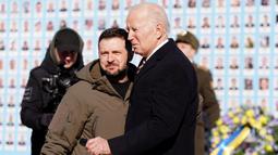 Presiden AS Joe Biden (kanan) disambut oleh Presiden Ukraina Volodymyr Zelensky (kiri) saat berkunjung di Kyiv, Ukraina pada 20 Februari 2023. Kunjungan Biden dilakukan jelang peringatan satu tahun invasi Rusia. Ia menyatakan bahwa dukungan Washington ke Kyiv tak tergoyahkan dan mengumumkan lebih banyak bantuan untuk Ukraina. (Dimitar DILKOFF/AFP)