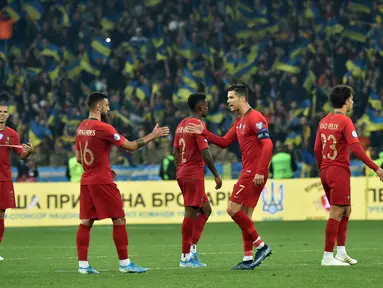 Penyerang Portugal, Cristiano Ronaldo memberi semangat rekan-rekannya usai pertandingan melawan Ukraina pada Grup B Kualifikasi Piala Eropa 2020 di Stadion NSK Olympiyskiy (15/10/2019). Ukraina menang tipis atas Portugal 2-1. (AFP Photo/Genya Savilov)