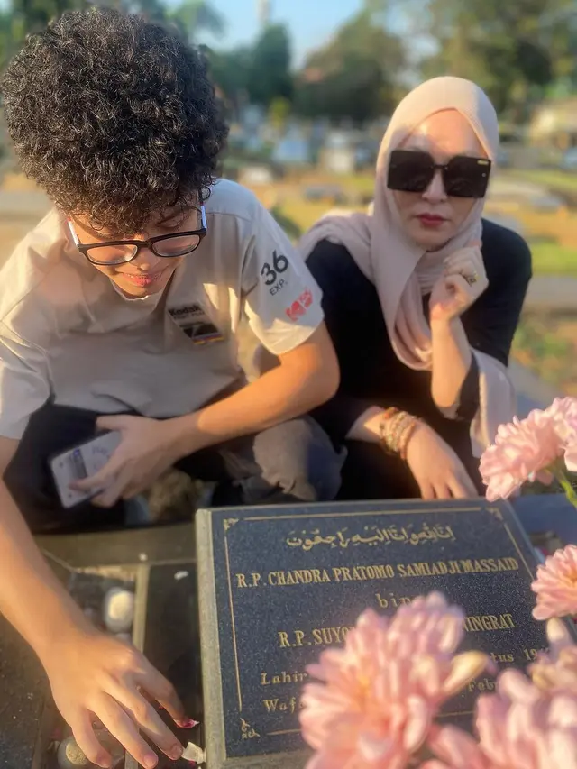 Angelina Sondakh dan anaknya di makam Adjie Massaid (Instagram/angelinasondakh09)