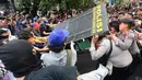 Pengunjuk rasa terlibat aksi saling dorong ketika mencoba membuka blokade aparat keamanan saat berunjuk rasa di kawasan jalan Jenderal Sudirman, Jakarta, Jumat (12/6/2026). (merdeka.com/Arie Basuki)