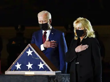 Presiden AS Joe Biden dan Ibu Negara Jill Biden memberi penghormatan kepada polisi yang tewas dalam kerusuhan Capitol Hill Brian Sicknick di tengah Capitol Rotunda, Washington, Selasa (2/2/2021). Abu jenazah Brian Sicknick dihadirkan dalam upacara ini. (Erin Schaff/The New York Times via AP, Pool)