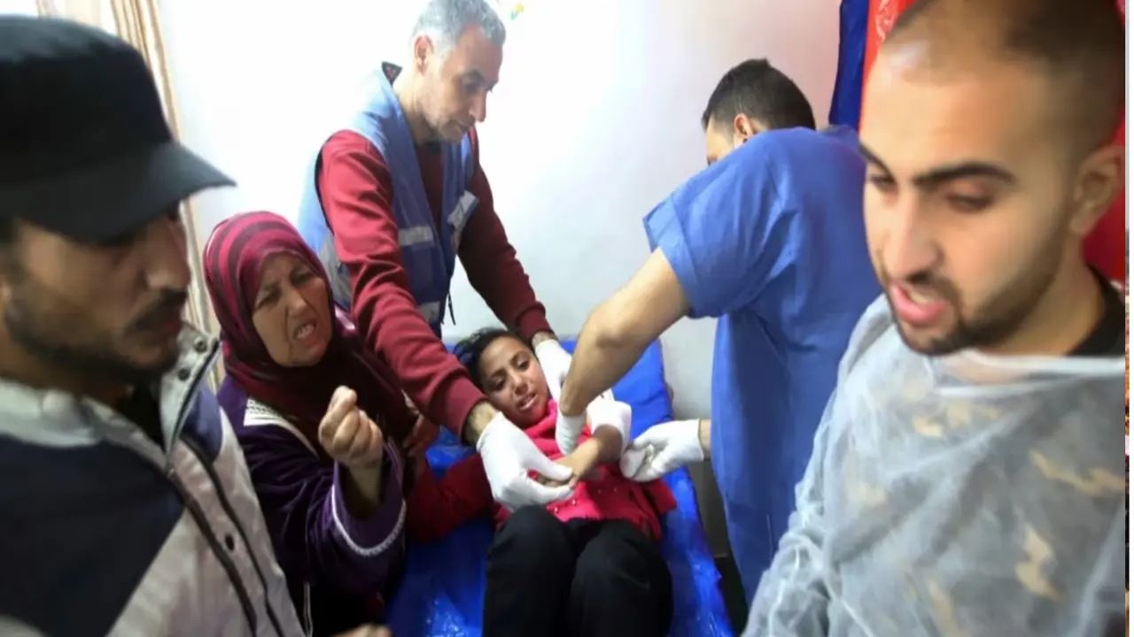 Petugas medis Palestina merawat seorang gadis terluka akibat pemboman Israel di sebuah gedung pusat pelatihan kejuruan UNRWA yang digunakan para pengungsi tempat berlindung di Khan Younis, Jalur Gaza selatan, 24 Januari 2024. (AP)