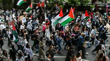 Para pengunjuk rasa memegang plakat dan mengibarkan bendera Palestina saat mereka mengambil bagian dalam “Pawai Nasional untuk Gaza”, di pusat kota London, pada 8 Juni 2024. (JUSTIN TALLIS/AFP)