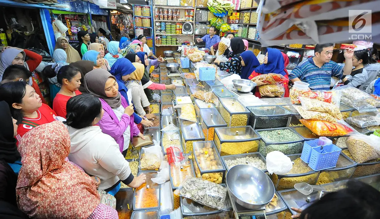 Sejumlah pembeli mengantre saat membeli kue kering di Pasar Jatinegara, Jakarta, Senin (27/5/2019). Jelang Idul Fitri 2019, banyak warga berburu makanan ringan seperti kue kering untuk jamuan di hari raya. (Liputan6.com/Angga Yuniar)