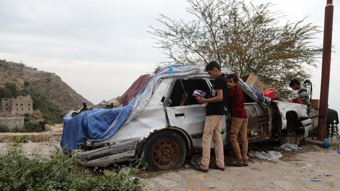 Anak-anak membeli permen di sebuah toko darurat di kawasan Jabal Sabr, Yaman pada 28 September 2019. Majd al-Din al-Shamiri (16) mengubah mobil keluarganya yang rusak parah, akibat perang yang melanda, menjadi toko darurat untuk mencari nafkah di tengah keadaan sulit. (Ahmad AL-BASHA/AFP)