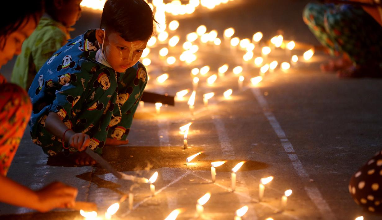 Seorang anak menyalakan lilin saat Festival Tazaungdaing di Yangon, Myanmar (29/11/2020). Festival Tazaungdaing, yang juga dikenal sebagai Festival Cahaya, jatuh pada hari bulan purnama di bulan kedelapan kalender tradisional Myanmar. (Xinhua/U Aung)