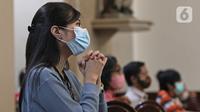 Jemaat umat kristiani berdoa saat melaksanakan Malam Misa Natal di Gereja Katedral Santo Petrus Bandung, Jawa Barat, Kamis (24/12/2020). Gereja membatasi jemaat yang hadir dalam pelaksanaan ibadah Natal maksimal 30 persen dari kapasitas ruangan ibadah. (Liputan6.com/Herman Zakharia)