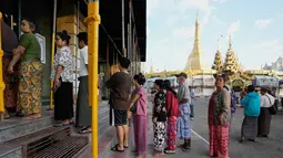 Ini merupakan pemilu pertama yang digelar dalam lima tahun terakhir sejak kudeta militer tahun 2021 yang memicu perang saudara berkepanjangan. Tampak dalam foto, para pemilih mengantre untuk memberikan suara mereka di tempat pemungutan suara, berlatar belakang Pagoda Sule, di Yangon, Myanmar, Minggu, 28 Desember 2025,  (AP Photo/Thein Zaw)