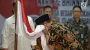 Perwakilan Keluarga Besar Harokah Islam Indonesia, mantan anggota DI/TII dan mantan anggota NII mencium bendera Merah Putih saat pembacaan ikrar setia kepada Pancasila, UUD 45, NKRI dan Bhineka Tunggal Ika di Jakarta, Selasa (13/8/2019). (merdeka.com/Imam Buhori)