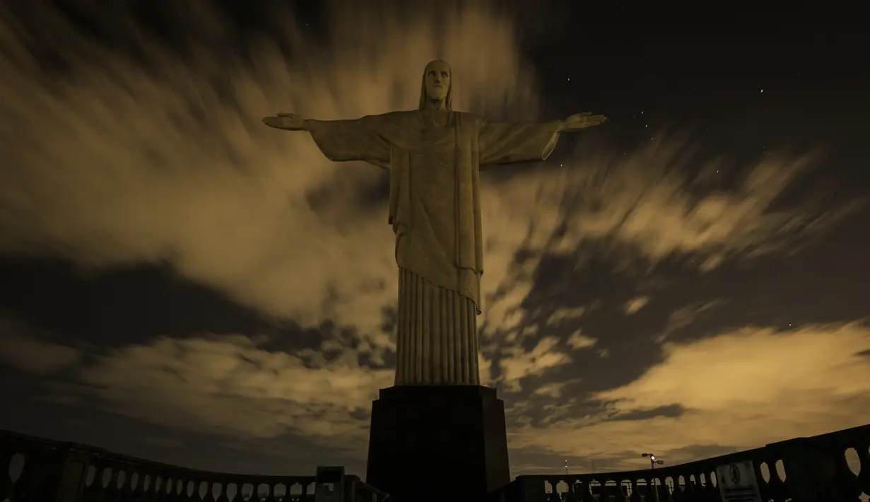 Patung Kristus Penebus terlihat padam tanpa lampu penerangan saat peringatan Earth Hour Internasional di Rio de Janeiro, Brasil (25/3). Kegiatan ini dilakukan dalam rangka memperingati hari bumi atau Earth Hour ke-10 atau 2017. (AFP/Yasuyoshi Chiba)