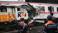 Para pekerja memeriksa kondisi lokomotif Kereta Api Jarak Jauh (KAJJ) Argo Bromo Anggrek dan salah satu gerbong Kereta Rel Listrik (KRL) Commuter Line yang mengalami kecelakaan di Stasiun Bekasi Timur, Bekasi, Jawa Barat, Selasa 28 April 2026. (AP Photo/Tatan Syuflana)
