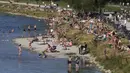 Orang-orang menikmati cuaca musim panas di tepi Sungai Isar, Munich, Jerman, 3 Agustus 2022. (AP Photo/Matthias Schrader)