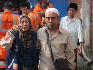 Seorang perempuan menangis ketika upaya penyelamatan sedang berlangsung setelah sebuah bangunan musala yang sedang dibangun runtuh di sebuah kompleks pesantren di Sidoarjo, Jawa Timur, Selasa 30 September 2025. (AP Photo/Trisnadi)