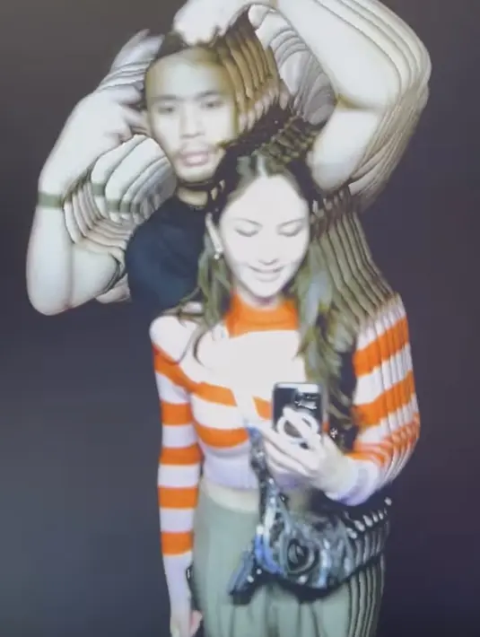 Saat pergi honeymoon ke museum, Jessica tampil dengan atasan knit wear lengan panjang warna merah dan pink dipadukan celana hijaunya. (@jscmila)