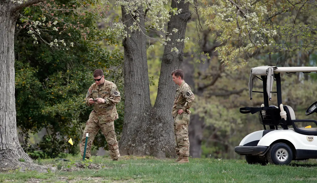 Penyidik memeriksa puing helikopter Blackhawk UH-60 milik Angkatan Darat AS yang jatuh di lapangan golf di Maryland Selatan, Senin (17/4). Seorang saksi mata lain mengatakan bahwa helikopter tersebut menabrak pohon saat jatuh. (AP Photo/Alex Brandon)