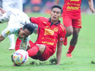 Pemain Persija Jakarta, Rizky Ridho, menghentikan laju gelandang Persib Bandung, Beckham Putra, dalam lanjutan Liga 1 Indonesia 2024/2025 di Stadion Patriot Candrabhaga, Bekasi, pada Minggu (16/2/2025). (Bola.com/M Iqbal Ichsan)