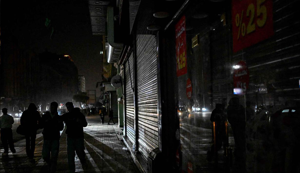 Penutupan Selat Hormuz berimbas pada harga energi di Mesir yang melonjak tajam. Tampak dalam foto, orang-orang berjalan di pusat kota Kairo, Mesir, setelah toko-toko tutup lebih awal karena pemberlakuan jam malam yang diperintahkan pemerintah untuk mengurangi biaya energi pada Kamis 2 April 2026. (Khaled DESOUKI/AFP)